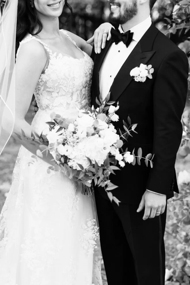 Elegant black and white portrait of bride and groom holding a wedding bouquet in Tuscany.