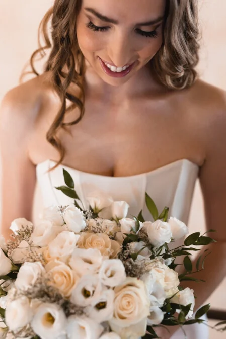 Close-up portrait of the bride holding a white rose bouquet on her wedding day in Tuscany, photographed by Vanni Frassoni