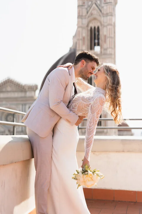 Romantic wedding portrait in Florence, Tuscany – bride and groom kissing with the Duomo in the background, captured by wedding photographer Vanni Frassoni
