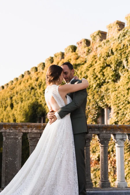 Bride and groom embracing during their wedding at Castello di Magona in Tuscany, captured in golden sunset light by wedding photographer Vanni Frassoni