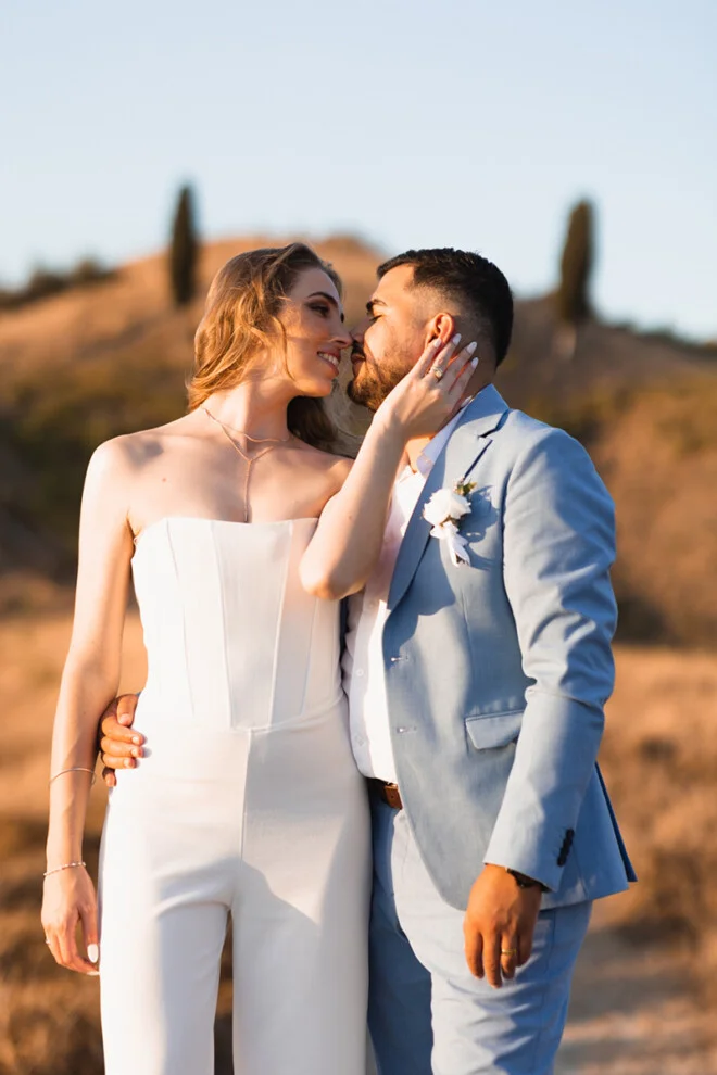 Bride and groom embracing at sunset in the Tuscan countryside of Certaldo.