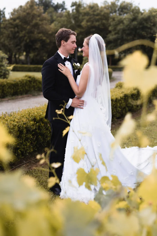 Romantic portrait of bride and groom in a vineyard in Tuscany during their wedding day.